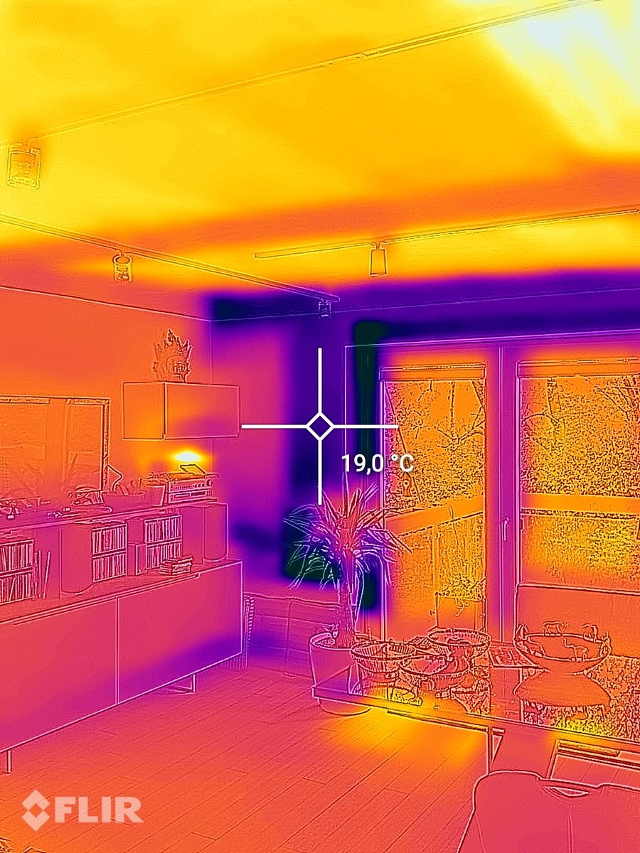 Immagine termografica di un soggiorno con soffitto caldo grazie al riscaldamento a soffitto e un punto di misura di 19,0 gradi sulla parete esterna accanto alla porta della terrazza.